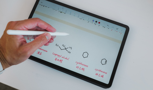 Mano utilizando un lápiz óptico sobre la pantalla de una tablet Redmi Pad 2 Pro con anotaciones de fórmulas químicas.