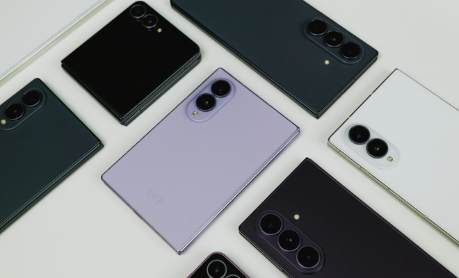Vista superior de varios teléfonos plegables de Samsung en diferentes colores y formatos sobre una superficie blanca.