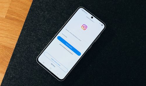 Smartphone mostrando el menú de inicio de sesión de la aplicación móvil de Instagram sobre una superficie oscura.
