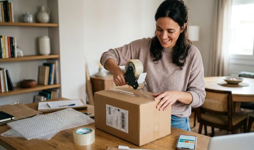 Mujer empaquetando un paquete de Vinted