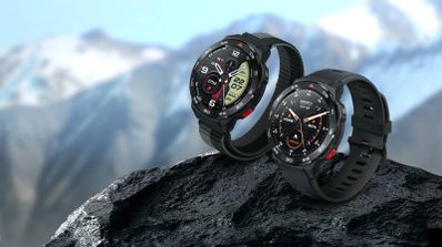 Dos relojes inteligentes Mibro GS Pro con diferentes correas sobre una roca con montañas nevadas al fondo.