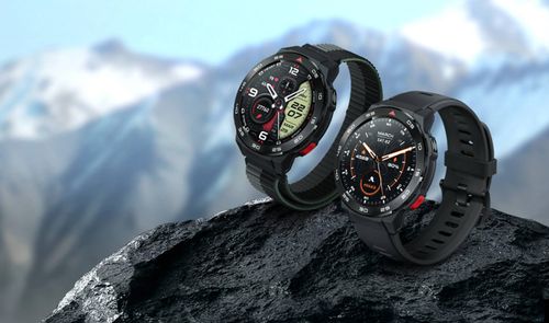 Dos relojes inteligentes Mibro GS Pro con diferentes correas sobre una roca con montañas nevadas al fondo.