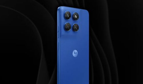 Parte trasera de un Motorola Moto G47 azul donde se aprecia el módulo con cuatro lentes de cámara y el logotipo central de la marca sobre un fondo oscuro.