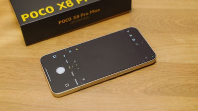 Teléfono inteligente con la aplicación de cámara abierta junto a su caja sobre una mesa de madera.