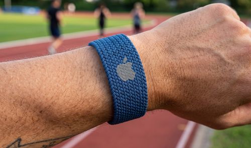 Hombre consultando la frecuencia cardíaca en su Apple Watch tras correr en un parque.