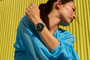 Reloj inteligente Google Pixel Watch 5 con esfera circular y correa deportiva en la muñeca de una mujer.