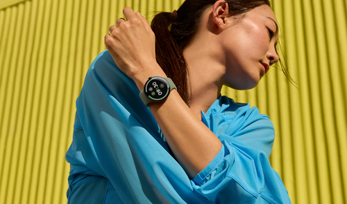 Reloj inteligente Google Pixel Watch 5 con esfera circular y correa deportiva en la muñeca de una mujer.