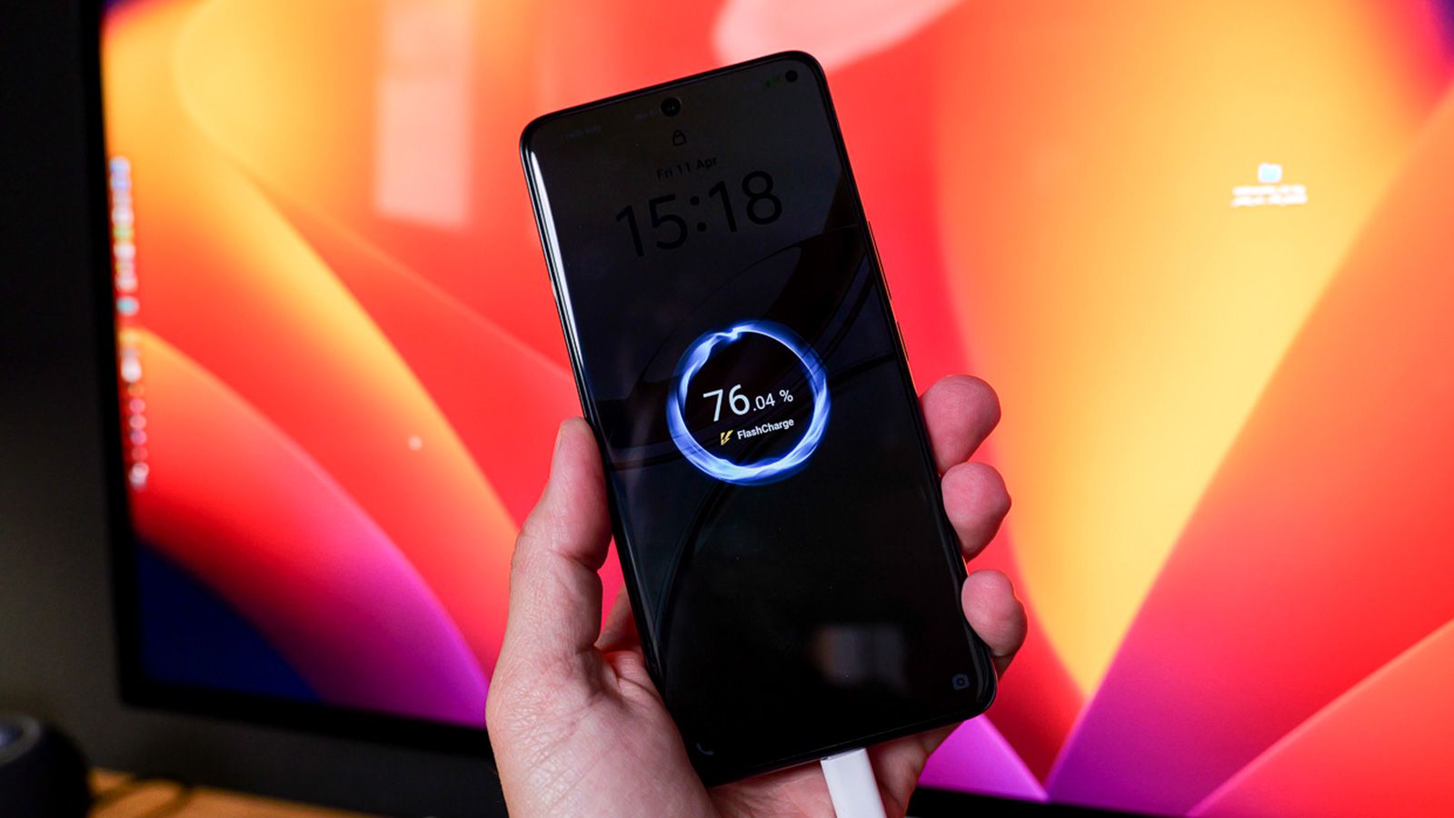 Primer plano de un smartphone vivo V50 5G mostrando la animación de carga rápida en pantalla mientras se sujeta con una mano.