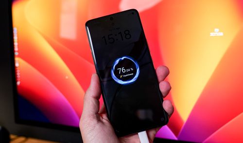 Primer plano de un smartphone vivo V50 5G mostrando la animación de carga rápida en pantalla mientras se sujeta con una mano.