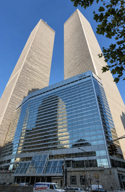 Perspectiva contrapicada de dos rascacielos gemelos y un edificio acristalado con el rótulo Vista.