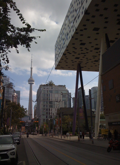 Calle de Toronto con la Torre CN al fondo y el edificio Sharp Centre for Design elevado a la derecha.