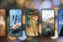 Cinco smartphones alineados mostrando diferentes estilos de personalización de fondos de pantalla y relojes en HyperOS.