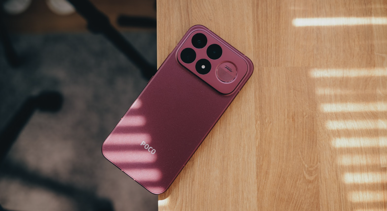 Plano cenital del teléfono POCO F9 Ultra apoyado sobre una mesa de madera con sombras lineales de persiana.
