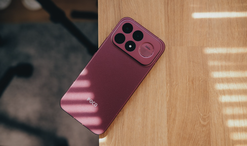 Plano cenital del teléfono POCO F9 Ultra apoyado sobre una mesa de madera con sombras lineales de persiana.