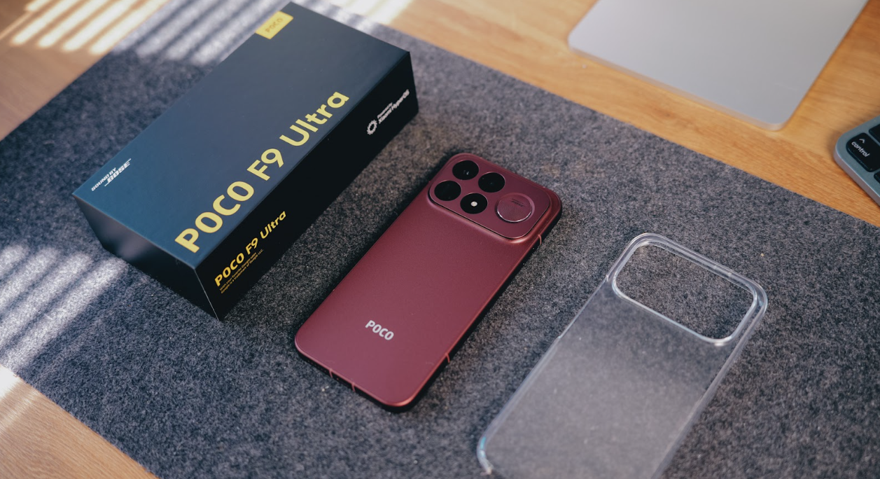 Teléfono POCO F9 Ultra junto a su caja de venta y una funda transparente sobre una alfombrilla gris.