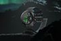 Reloj inteligente Polar Grit X2 Pro Titan sobre una roca bajo una aurora boreal.