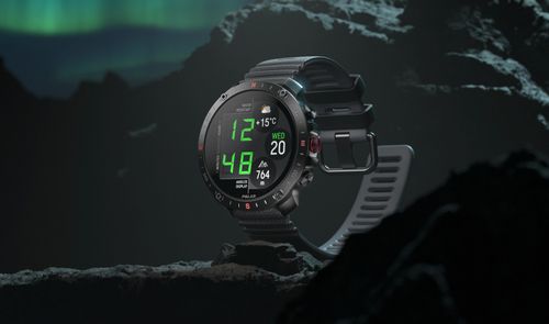 Reloj inteligente Polar Grit X2 Pro Titan sobre una roca bajo una aurora boreal.