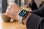 Reloj inteligente Redmi Watch 6 Active con esfera digital en la muñeca de un usuario en una cafetería.