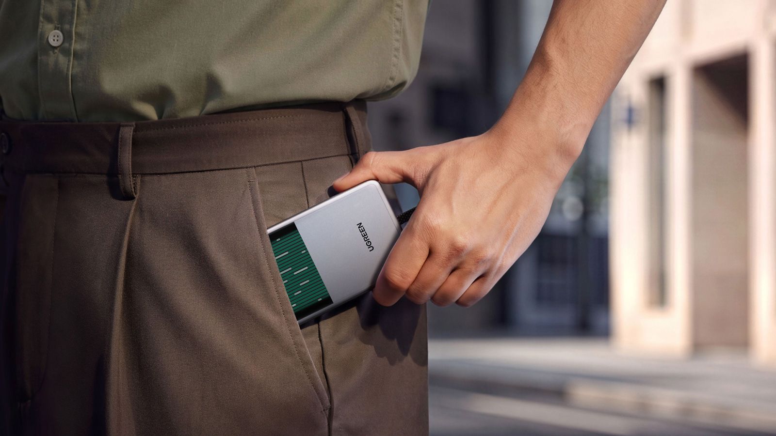 Batería externa UGREEN MagFlow Pro Magnetic introduciéndose en el bolsillo de un pantalón.