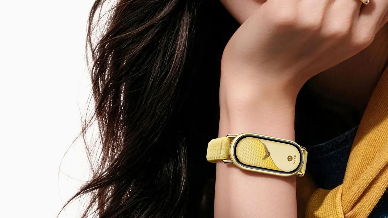 Primer plano de la pulsera inteligente Xiaomi Smart Band 11 con correa amarilla y esfera a juego colocada en la muñeca de una mujer.