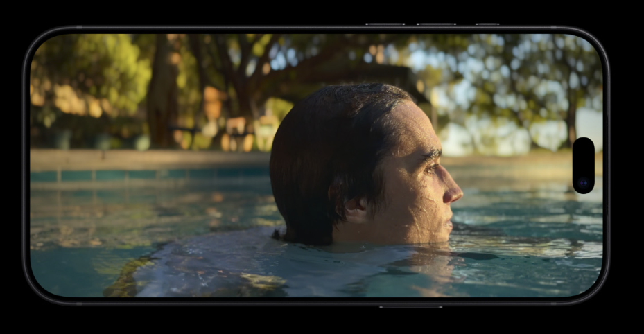 Primer plano de un hombre en una piscina visto a través de la pantalla de un iPhone 18 Pro en posición horizontal.