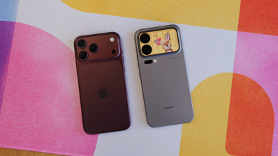 Vista trasera de un iPhone 18 Pro Max en color granate junto a un Xiaomi 18 Pro Max con pantalla secundaria en el módulo de cámaras sobre una superficie de colores.