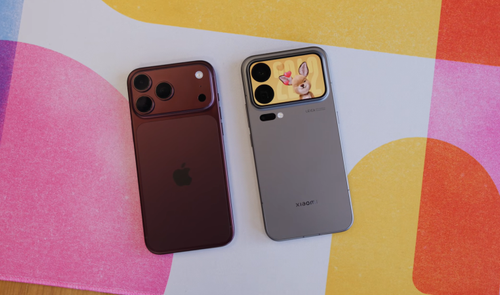 Vista trasera de un iPhone 18 Pro Max en color granate junto a un Xiaomi 18 Pro Max con pantalla secundaria en el módulo de cámaras sobre una superficie de colores.