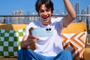 Joven sentado en una terraza sosteniendo en horizontal un REDMI Note 17 Pro 5G mientras celebra una partida.