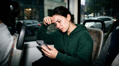 Persona mareada mientras utiliza el móvil en el autobús