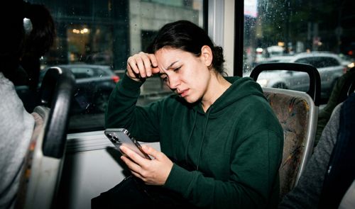 Persona mareada mientras utiliza el móvil en el autobús