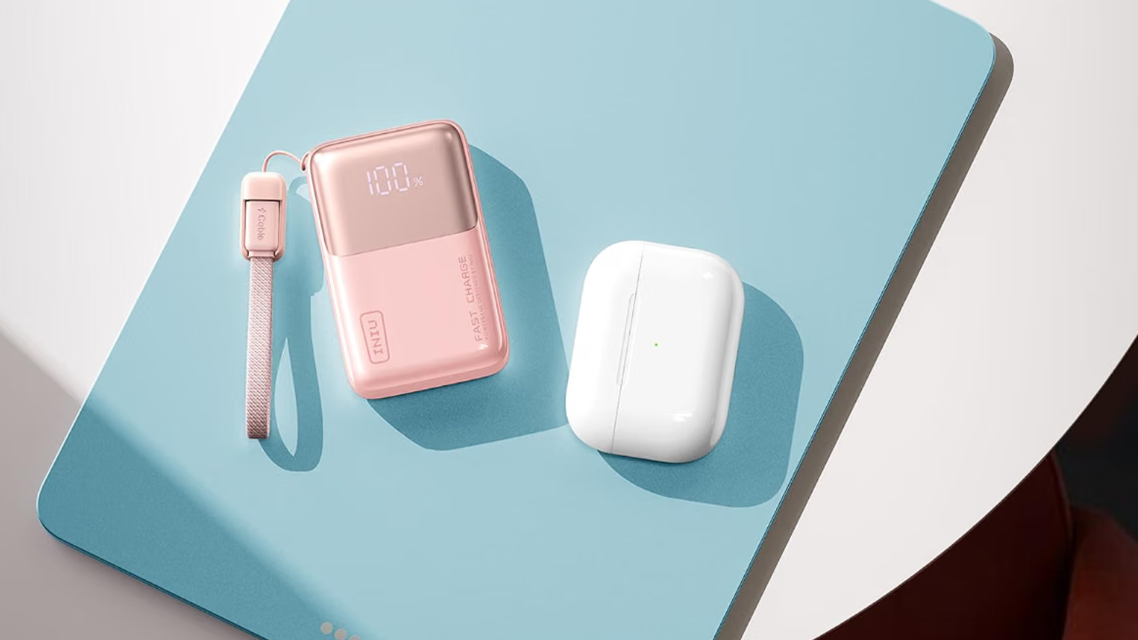 Powerbank de bolsillo Iniu con 10.000 mAh junto a estuche de auriculares