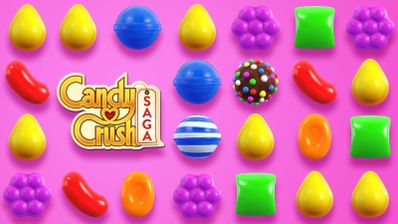 Tablero de juego de Candy Crush Saga con caramelos de colores sobre fondo rosa.