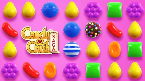 Tablero de juego de Candy Crush Saga con caramelos de colores sobre fondo rosa.