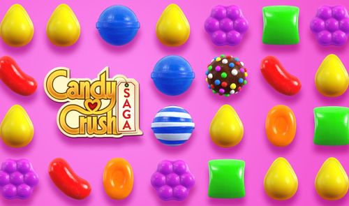 Tablero de juego de Candy Crush Saga con caramelos de colores sobre fondo rosa.
