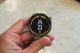 Primer plano de un Huawei Watch GT7 con correa de color verde lima sostenido por una mano.