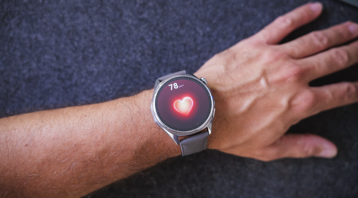 Primer plano de un Huawei Watch GT7 en la muñeca midiendo la frecuencia cardíaca, mostrando un icono de corazón rojo y la cifra de 78 pulsaciones por minuto.