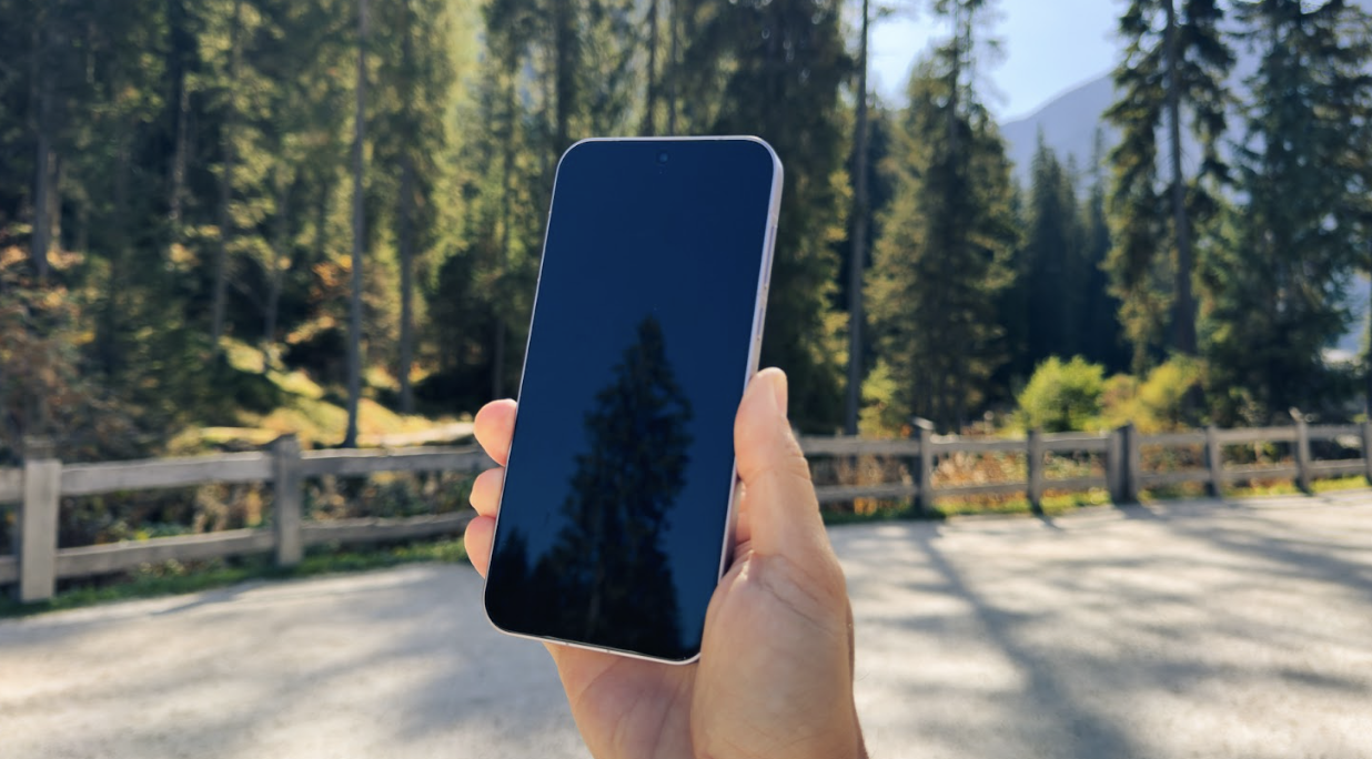Parte frontal del OPPO Find X10 Pro Max sostenido con una mano en exteriores con la pantalla apagada.