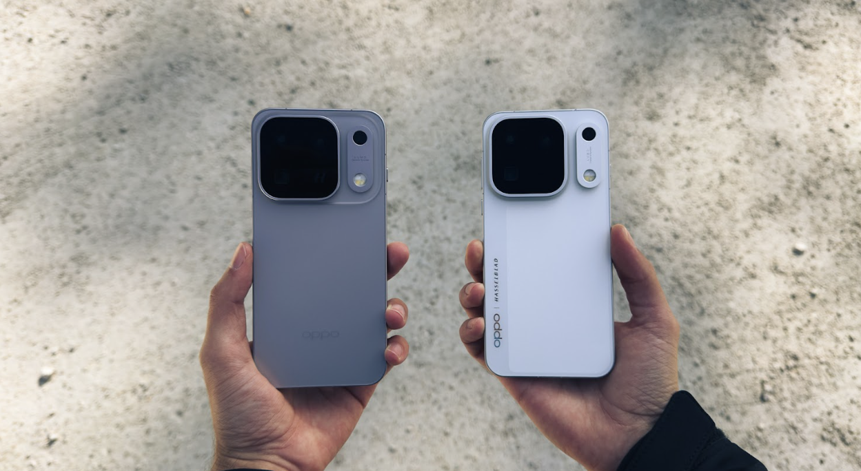 Dos unidades del smartphone OPPO Find X10 Pro Max, una en color gris y otra en blanco, sujetas por ambas manos frente a un suelo de tierra.