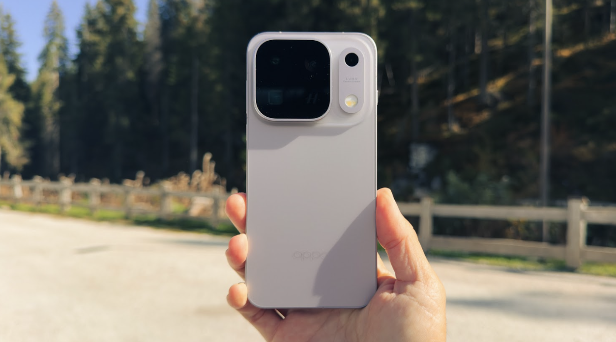 Primer plano del reverso de un smartphone OPPO Find X10 Pro Max sujeto con una mano en un entorno exterior boscoso.