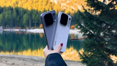Parte trasera de dos teléfonos de la gama OPPO Find X10 Series sostenidos frente a un lago de montaña.