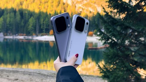 Parte trasera de dos teléfonos de la gama OPPO Find X10 Series sostenidos frente a un lago de montaña.