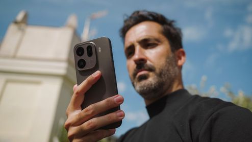 Primer plano del módulo de cámaras trasero del OPPO Find X9 sostenido por un hombre en exteriores.