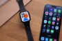 Reloj inteligente REDMI Watch 6 Lite con correa negra al lado de un teléfono móvil sobre una mesa de madera.