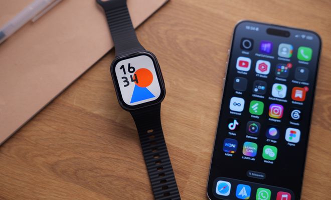 Reloj inteligente REDMI Watch 6 Lite con correa negra al lado de un teléfono móvil sobre una mesa de madera.