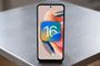 Teléfono Redmi Note 12 apoyado en una mesa con el logotipo del sistema operativo iOS 16 superpuesto en pantalla.