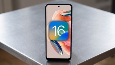 Teléfono Redmi Note 12 apoyado en una mesa con el logotipo del sistema operativo iOS 16 superpuesto en pantalla.