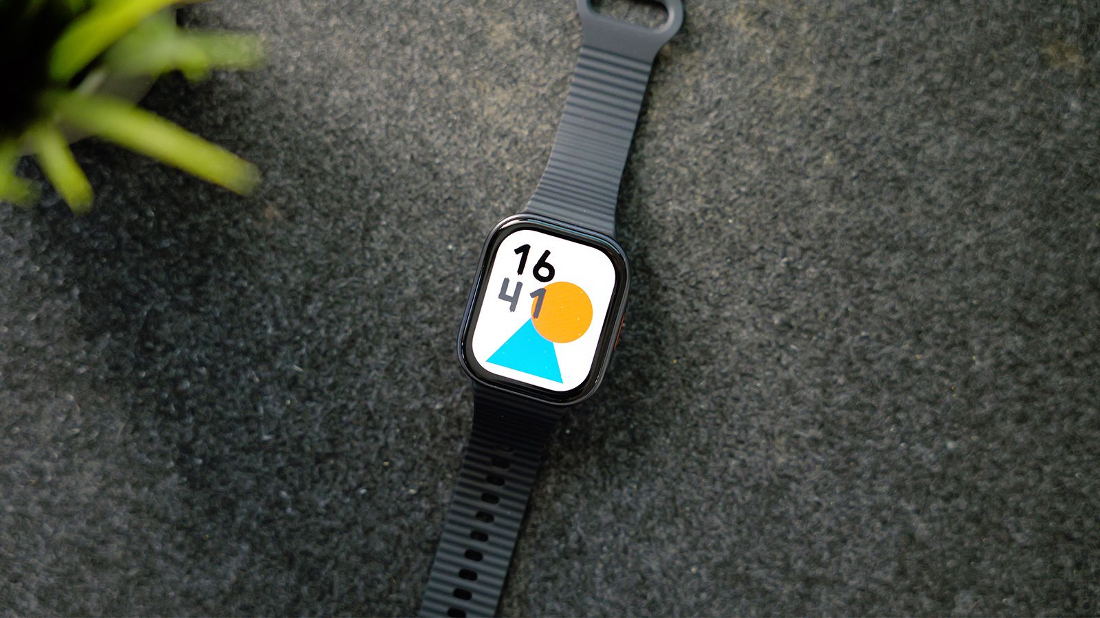 Reloj inteligente Redmi Watch 6 Lite con correa negra y esfera minimalista sobre superficie rugosa.