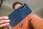Parte trasera de un teléfono Samsung Galaxy A57 5G en color azul oscuro con tres cámaras verticales.