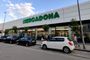 Fachada exterior de un supermercado Mercadona con clientes y vehículos aparcados