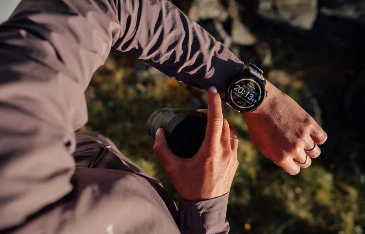Primer plano de una persona consultando la pantalla del reloj Suunto Vertical 2 durante una actividad al aire libre.